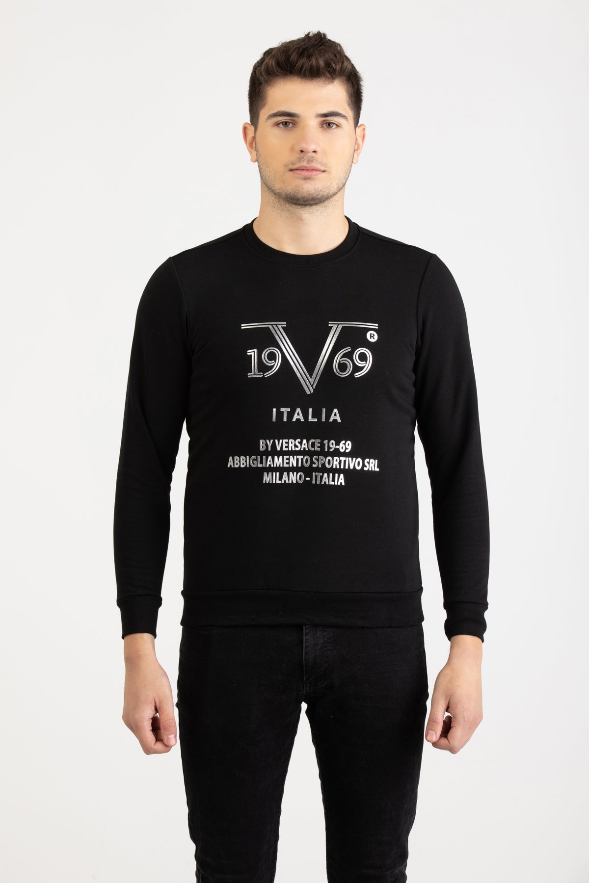 Front view of a man wearing a black Versace 19.69 Abbigliamento Sportivo sweatshirt with silver 19V69 Milano Italia linear logo.
