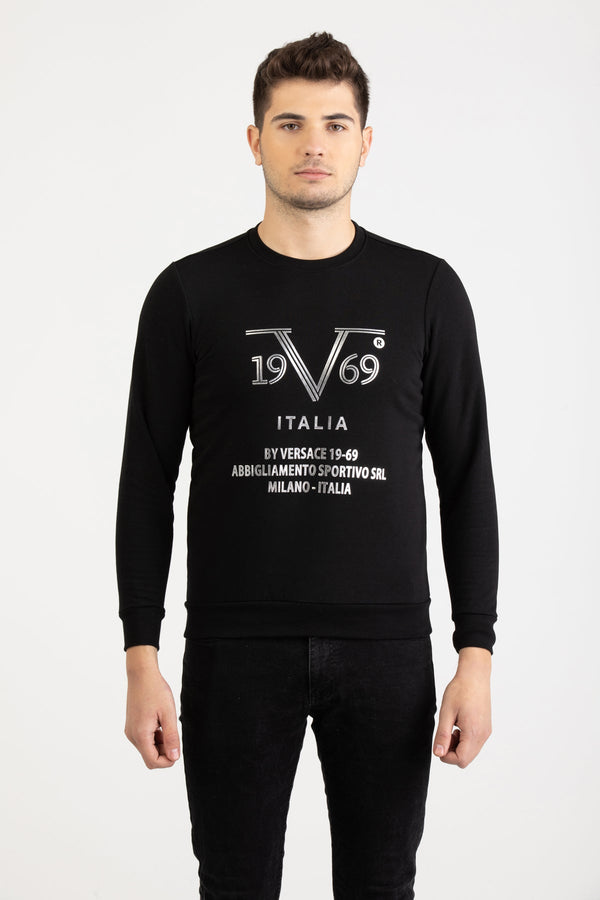 Front view of a man wearing a black Versace 19.69 Abbigliamento Sportivo sweatshirt with silver 19V69 Milano Italia linear logo.