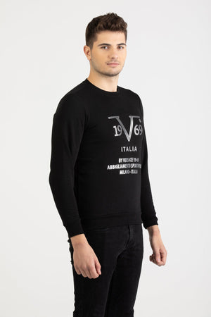 Front view of a man wearing a black Versace 19.69 Abbigliamento Sportivo sweatshirt with silver 19V69 Milano Italia linear logo.