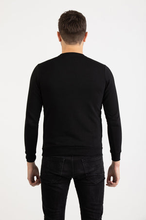 Front view of a man wearing a black Versace 19.69 Abbigliamento Sportivo sweatshirt with silver 19V69 Milano Italia linear logo.