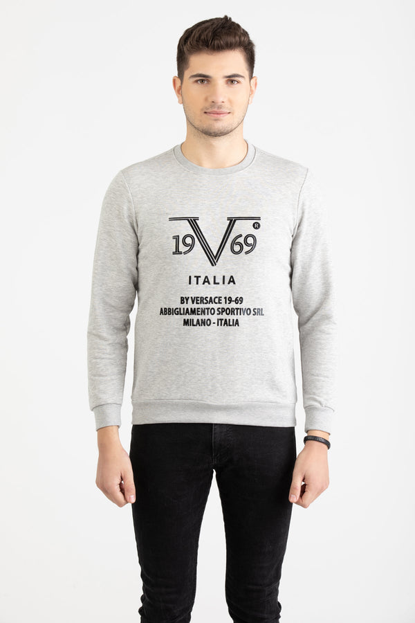 Man wearing a heather grey Versace 19.69 sweatshirt with black linear 19V69 Italia branding.