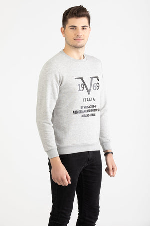 Man wearing a heather grey Versace 19.69 sweatshirt with black linear 19V69 Italia branding.