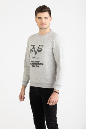 Man wearing a heather grey Versace 19.69 sweatshirt with black linear 19V69 Italia branding.
