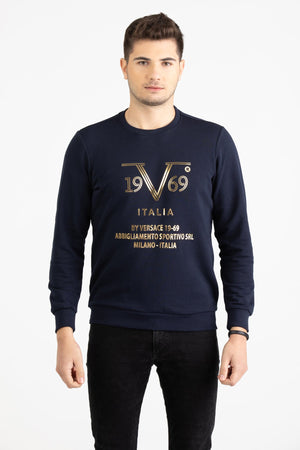 Man wearing a navy blue Versace 19.69 sweatshirt with a metallic gold linear 19V69 Italia graphic.