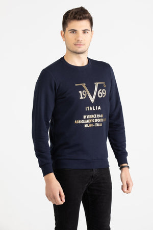 Man wearing a navy blue Versace 19.69 sweatshirt with a metallic gold linear 19V69 Italia graphic.