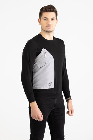 Man wearing a black Versace 19.69 sweatshirt featuring a large grey nylon utility pocket with zipper and snap details.