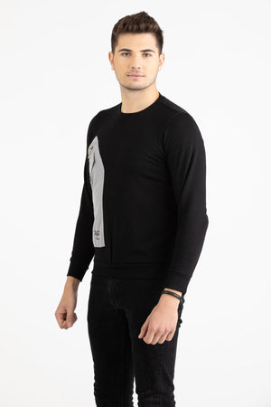Man wearing a black Versace 19.69 sweatshirt featuring a large grey nylon utility pocket with zipper and snap details.
