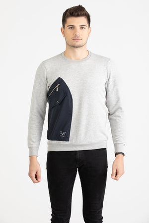 Man wearing a heather grey Versace 19.69 sweatshirt featuring a large navy nylon utility pocket with zipper and snap details.