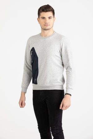 Man wearing a heather grey Versace 19.69 sweatshirt featuring a large navy nylon utility pocket with zipper and snap details.