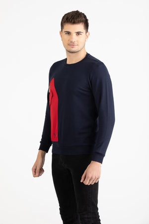 Man wearing a navy blue Versace 19.69 sweatshirt featuring a large red nylon utility pocket with zipper and snap details.