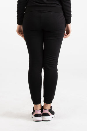 Close-up view of black Versace 19.69 joggers for women featuring a drawstring waist and small silver 19V69 Italia logo on the thigh.